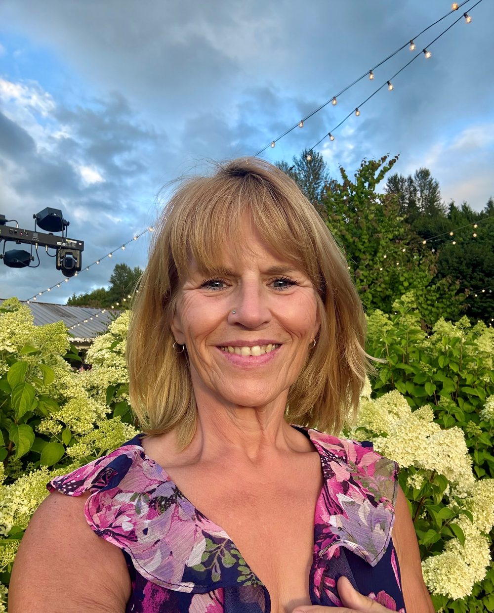 Portrait of Rhonda Covert smiling outdoors under string lights